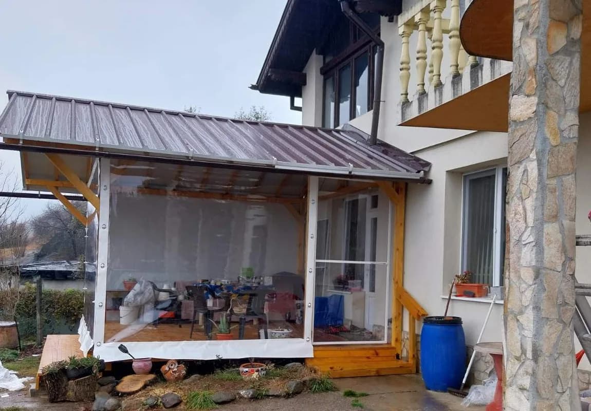 Навес с дървена конструкция и прозрачна PVC завеса към тераса на къща